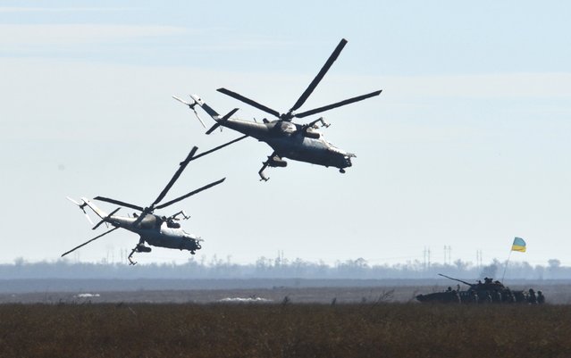 Military helicopters fly in formation during military exercises conducted by Ukrainian armed forces at the Shiroky Lan training ground in Mykolaiv region, Ukraine, October 30, 2015. The military training exercises, which involved air force, self-propelled vehicles and other armament, were focused on the interaction between different units of the army, according to representatives of the ministry of defence. (Photo by Oleksandr Klymenko/Reuters)