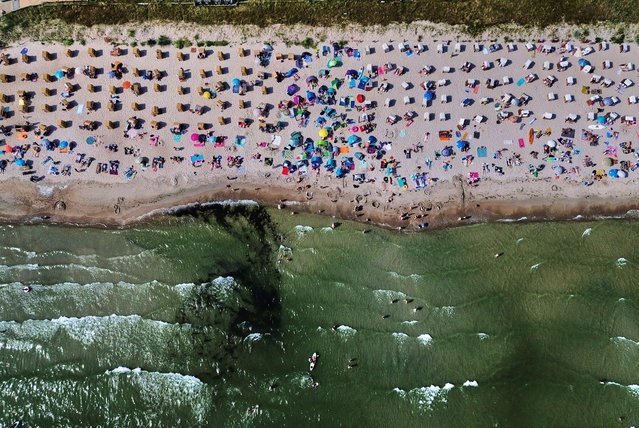 People spend the day at the beach of the Baltic Sea in Scharbeutz, northern Germany, Wednesday, August 13, 2025. (Photo by Michael Probst/AP Photo)