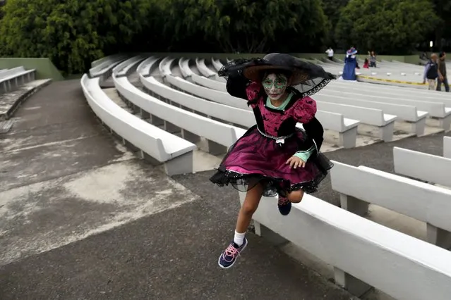 A girl with her face painted to look like the popular Mexican figure called "Catrina",  jumps as she takes part in the annual Catrina Fest in Mexico City November 1, 2015. (Photo by Carlos Jasso/Reuters)