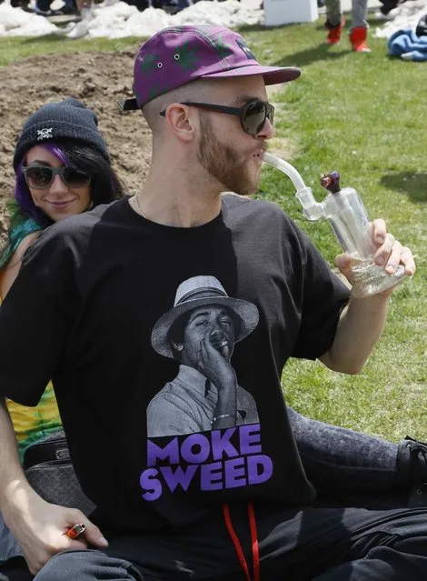 A participant at the 4/20 marijuana holiday smokes a pipe in Civic Center Park in downtown Denver April 20, 2013. (Photo by Rick Wilking/Reuters)