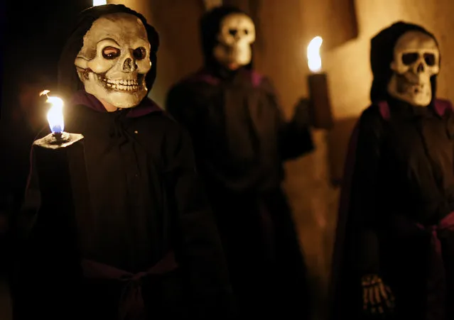 Dancers perform the Dance of the Death during a Holy Week procession in Verges, northeastern Spain, on March 30, 2018. Dancers dress in body stockings with skeletons painted on them and carry symbols to stir the people and prepare them for a good death. Christian believers around the world mark the Holy Week of Easter in celebration of the crucifixion and resurrection of Jesus Christ. (Photo by Pau Barrena/AFP Photo)