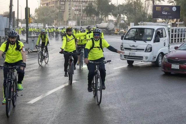 Members of a cycling club take to the roads for a 50-kilometer (31-mile) trip in Baghdad, Iraq, on Tuesday, February 28, 2023. The group organizes rides weekly for scores of men and women who see bike-riding as a healthy way to relieve life's stress and for good company. (Photo by Jerome Delay/AP Photo)