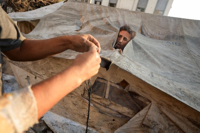 Palestinians repair their tent that was damaged in an overnight Israeli air strike on a house, in Gaza City, on September 13, 2025. (Photo by Dawoud Abu Alkas/Reuters)