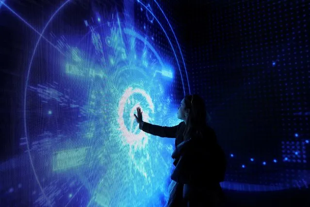 A woman visits a video experience zone at the 2023 Mobile World Congress (MWC) in Barcelona, Spain on February 27, 2023. (Photo by Nacho Doce/Reuters)
