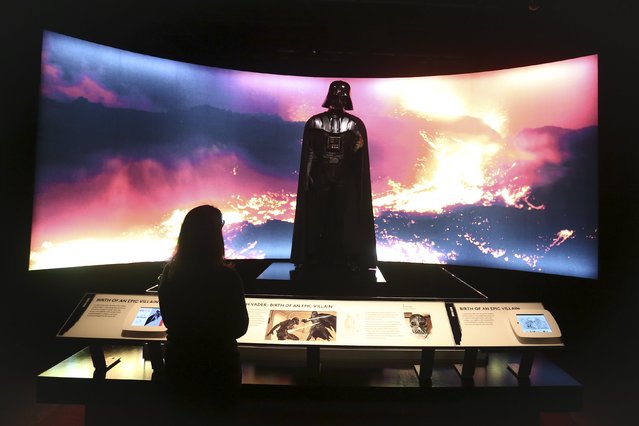 A woman looks at a Darth Vader costume used in Star Wars movies at the Discovery Store Times Square in the Manhattan borough of New York November 11, 2015. (Photo by Carlo Allegri/Reuters)