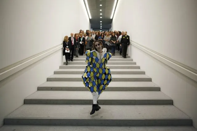 Spanish dancer and choreographer Ruben Olmo, who was newly awarded with the National Dance Award 2015 of Spain, dances as he leads a crowd to the stage during a performance titled "Architecture of light and shadows", at the Malaga Centre Pompidou in Malaga, southern Spain, November 14, 2015. Olmo is wearing a costume designed by Spanish architect, designer and artist Myriam Hurtado. (Photo by Jon Nazca/Reuters)