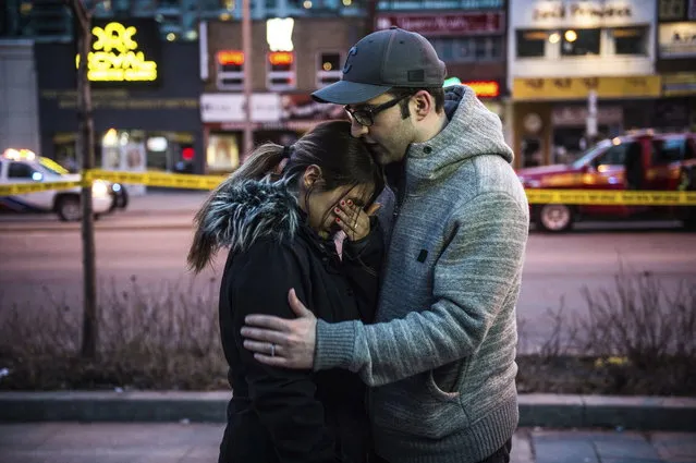 Farzad Salehi consoles his wife, Mehrsa Marjani, who was at a nearby cafe and witnessed the aftermath when a van plowed down a crowded sidewalk, killing multiple people and injuring others, Monday, April 23, 2018, in Toronto. (Photo by Aaron Vincent Elkaim/The Canadian Press via AP Photo)