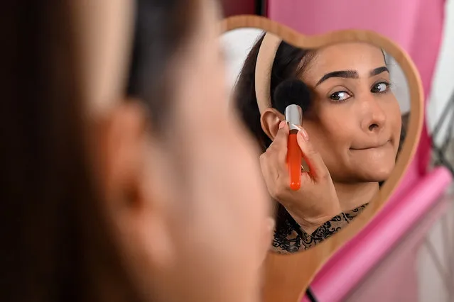 In this photo taken on March 17, 2023, social media influencer and make-up artist Faby does her make-up while going live on her YouTube channel in Mumbai. (Photo by Sujit Jaiswal/AFP Photo)