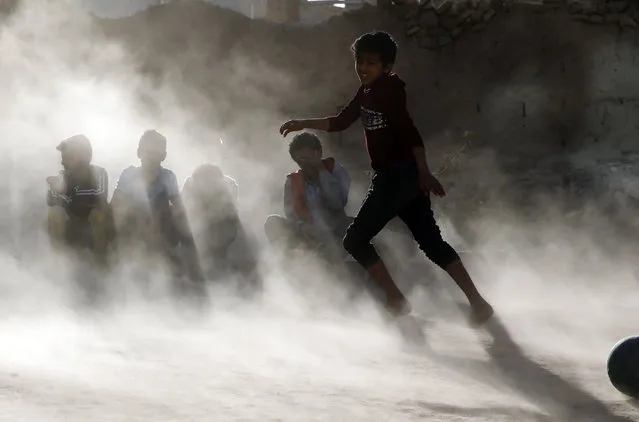 A dust storm hits a field as Yemeni children play soccer on the eve of World Children's Day, in Sana'a, Yemen, 19 November 2022. World Children's Day is observed annually on 20 November to highlight children in demanding action to protect and promote child rights as well as improving children's welfare. It also marks the Declaration of the Rights of the Child by the UN General Assembly on that day in 1959. (Photo by Yahya Arhab/EPA/EFE/Rex Features/Shutterstock)