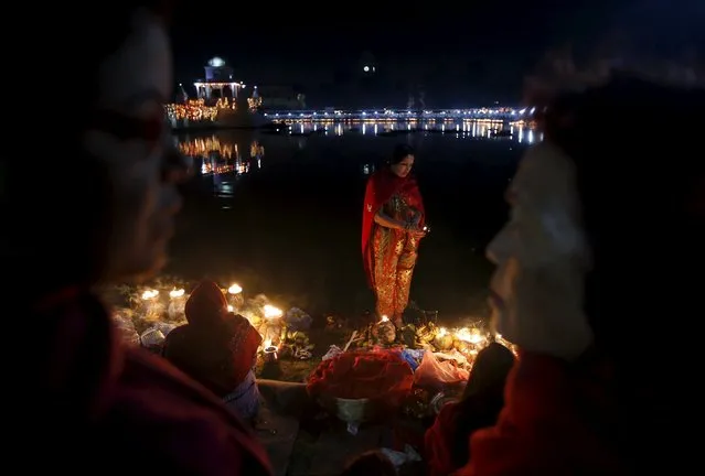 A devotee holding oil lamp waits for sunrise to offer prayers to the rising sun during the "Chhat" festival in Kathmandu, Nepal November 18, 2015. (Photo by Navesh Chitrakar/Reuters)