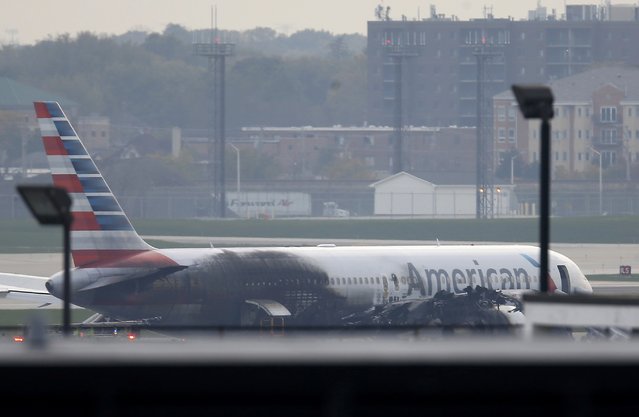 Soot covers the fuselage of an American Airlines jet that blew a tire, sparking a fire and prompting the pilot to abort takeoff before passengers were evacuated from the plane via emergency chute, at O'Hare International Airport in Chicago, Illinois, U.S.October 28, 2016. (Photo by Jim Young/Reuters)