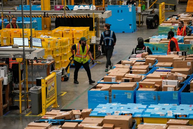 Workers move products during Cyber Monday at Amazon's fulfilment center in Robbinsville, New Jersey, U.S., December 1, 2025. (Photo by Eduardo Munoz/Reuters)