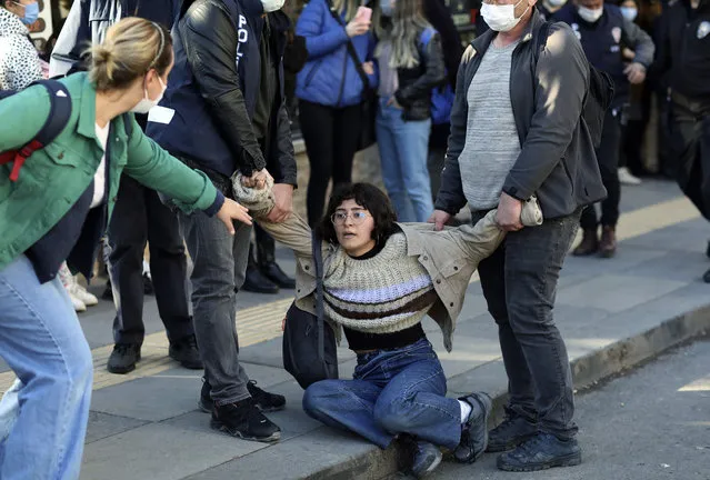 A woman reacts as riot police officers detain a student during a protest, in Ankara, Turkey, Friday, February 5, 2021. Students and faculty members at Bogazici University have been staging demonstrations in protest of President Recep Tayyip Erdogan's Jan. 1 appointment of an academic with links to his ruling party, as rector. (Photo by Burhan Ozbilici/AP Photo)
