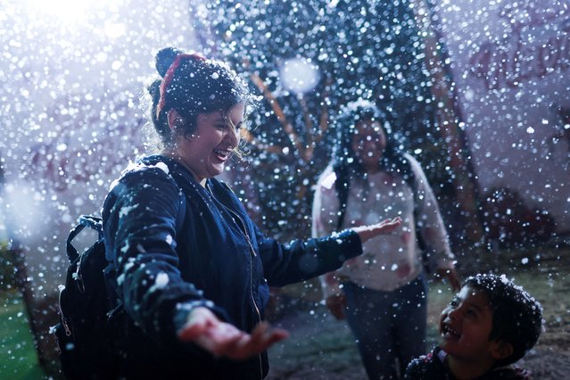 People play with soap suds simulating snowfall at Zocalo Square as part of Christmas celebrations in Mexico City on December 18, 2024. (Photo by Raquel Cunha/Reuters)