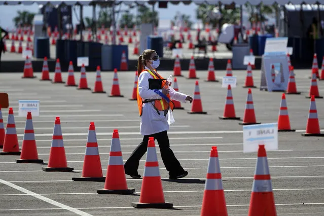 Sossie Bedrossian, head of nursing for the Los Angeles school district, walks in the parking lot of a COVID-19 vaccination site for district employees at SOFI Stadium Tuesday, March 2, 2021, in Inglewood, Calif. (Photo by Marcio Jose Sanchez/AP Photo)