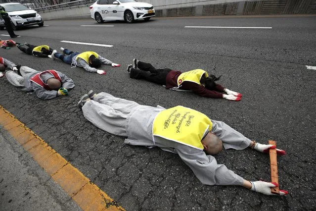 South Korean Buddhist monks and Myanmar nationals living in South Korea prostrate on the road in a march as they protest calling for the recovery of Myanmar's democracy and against the military coup near the Myanmar embassy in Seoul, South Korea, Friday, March 12, 2021. (Photo by Lee Jin-man/AP Photo)