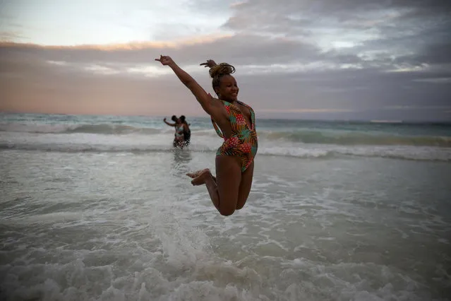 An American tourist poses for a photo while jumping in the air photo in the shallow waters of a beach in Tulum, Quintana Roo state, Mexico, Monday, January 4, 2021. More U.S. tourists came to Quintana Roo during this pandemic-stricken holiday season than did a year earlier when the world was just beginning to learn of the new coronavirus. (Photo by Emilio Espejel/AP Photo)