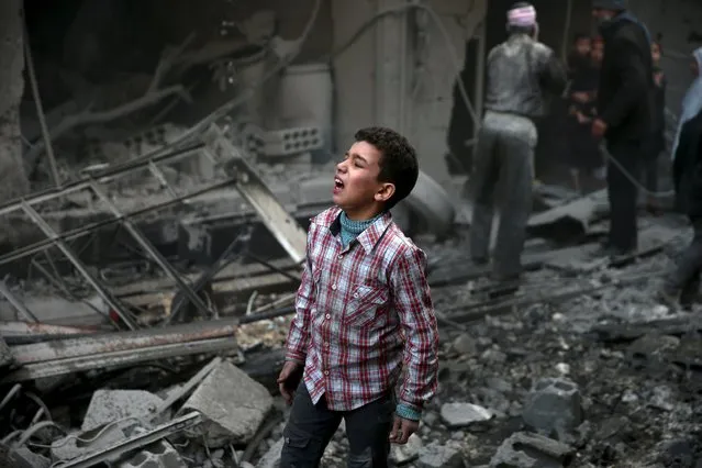 A boy reacts in a site hit by what activists said were airstrikes carried out by the Russian air force in the town of Douma, eastern Ghouta in Damascus, Syria January 10, 2016. (Photo by Bassam Khabieh/Reuters)