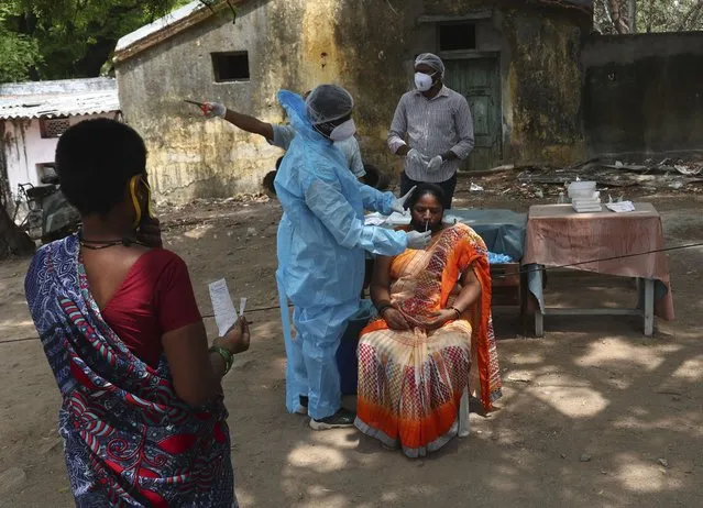A health worker takes a nasal swab sample of a woman to test for COVID-19 in Hyderabad, India, Friday, May 7, 2021. With coronavirus cases surging to record levels, Indian Prime Minister Narendra Modi is facing growing pressure to impose a harsh nationwide lockdown amid a debate whether restrictions imposed by individual states are enough. (Photo by Mahesh Kumar A./AP Photo)