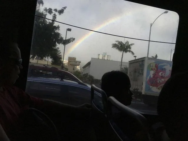 A rainbow brightens the sky as commuters make their way home on a city bus in afternoon traffic in downtown Honolulu, Hawaii December 22, 2015. (Photo by Jonathan Ernst/Reuters)