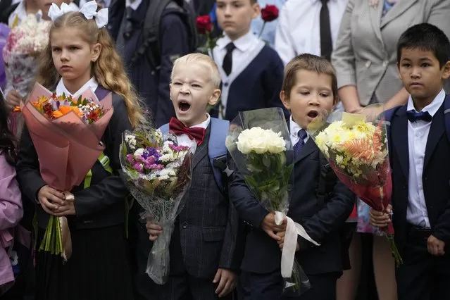First graders take part in a ceremony marking the start of classes at a school as part of the traditional opening of the school year known as “Day of Knowledge” in St. Petersburg, Russia, Friday, Sept. 1, 2023.  Many schools across the country reopen on Sept. 1. (Photo by Dmitri Lovetsky/AP Photo)