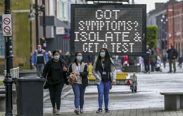 An electronic notice board advises local people to isolate and get tested if they have coronavirus symptoms, in the town centre of Bolton, England, Tuesday May 25, 2021. The British government on Tuesday is facing accusations of introducing local lockdowns by stealth after it published new guidelines for eight areas in England, including Bolton, that it says are hotspots for the coronavirus variant first identified in India. (Photo by Peter Byrne/PA Wire via AP Photo)