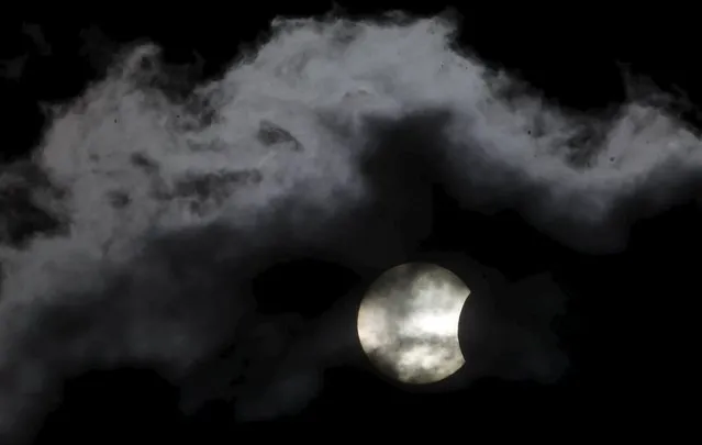 A partial solar eclipse is seen through clouds in Sarajevo March 20, 2015. (Photo by Dado Ruvic/Reuters)