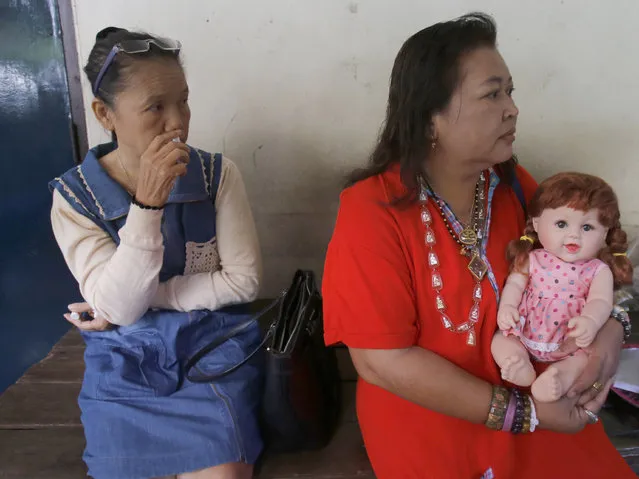 In this Thursday, January 28, 2016 photo, a Thai woman holds a “child angel” doll in Bangkok, Thailand. (Photo by Sakchai Lalit/AP Photo)