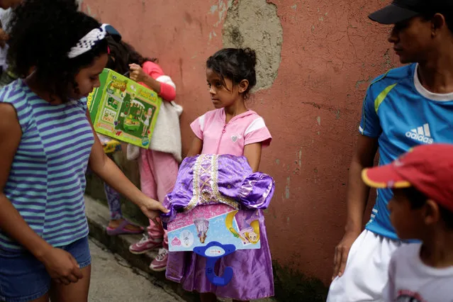Children attend a toy distribution program with Miguel Pizarro, deputy of the Venezuelan coalition of opposition parties (MUD), in a school at the slum of Petare in Caracas, Venezuela December 20, 2016. (Photo by Marco Bello/Reuters)
