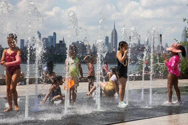 Children cool off in a fountain during a heatwave in the Brooklyn borough of New York, the United States, on June 29, 2021. New York City is gripped by multi-day scorching heat and humidity as much of the East Coast is expected to see temperatures top 90 degrees Fahrenheit (about 32 degrees Celsius) until Wednesday. (Photo by Xinhua News Agency/Rex Features/Shutterstock)