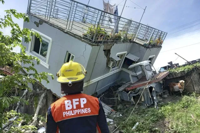 In this photo provided by the Bureau of Fire Protection, rescuers check on a damaged house wall after a strong earthquake struck Santiago, Ilocos Sur province, Philippines on Wednesday July 27, 2022. A strong earthquake shook the northern Philippines on Wednesday, causing some damage and prompting people to flee buildings in the capital. (Photo by Bureau of Fire Protection via AP Photo)