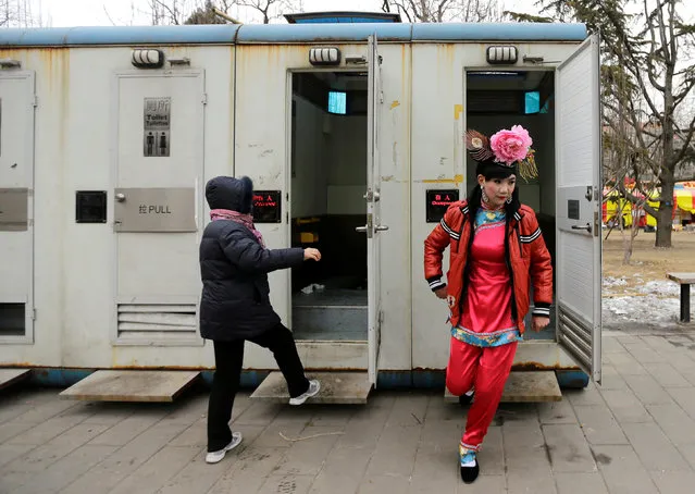 A male folk artist (R) dressed as a traditional Chinese woman walks out of a mobile toilet ahead of a performance at a Spring Festival Temple Fair on the fifth day of the Chinese Lunar New Year at Longtan Park in Beijing, China February 14, 2013. (Photo by Jason Lee/Reuters)