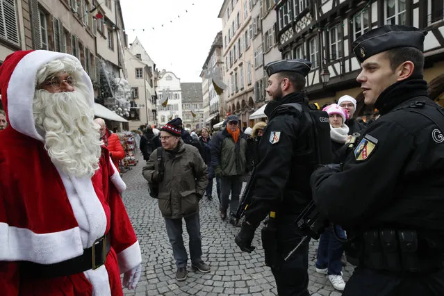 A man dressed like a Santa Claus watches police officers patrolling near the Christmas market reopens in Strasbourg, eastern France, Friday, December 14, 2018. The man authorities believe killed three people during a rampage near a Christmas market in Strasbourg died Thursday in a shootout with police at the end of a two-day manhunt, French authorities said. (Photo by Christophe Ena/AP Photo)
