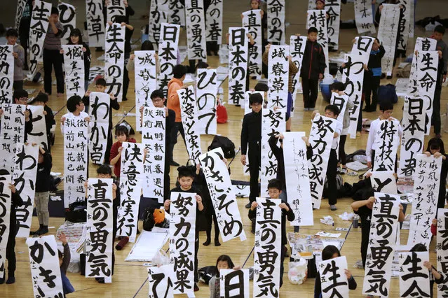 Participants show off their traditional Japanese calligraphy works during the annual New Year's calligraphy contest at the Budokan martial arts hall in Tokyo, Thursday, January 5, 2017. (Photo by Eugene Hoshiko/AP Photo)