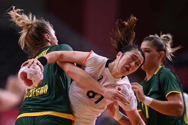 Japan's centre wing Mayuko Ishitate (C) is challenged during the women's preliminary round group A handball match between Japan and Montenegro of the Tokyo 2020 Olympic Games at the Yoyogi National Stadium in Tokyo on July 27, 2021. (Photo by Daniel Leal-Olivas/AFP Photo)