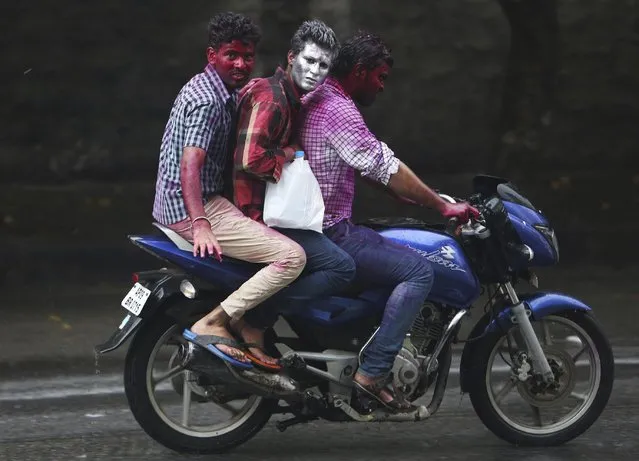 In this March 6, 2015 file photo, Indian men, their faces smeared with colored powder, ride a motorbike on Holi the Hindu festival of colors, in Hyderabad, India. British rock band Coldplay's latest music video has triggered a debate in India over its portrayal of the country with critics accusing its producers of showing stereotypical images of India with Hindu holy men, peacocks and colorful festivals. (Photo by Mahesh Kumar A./AP Photo)