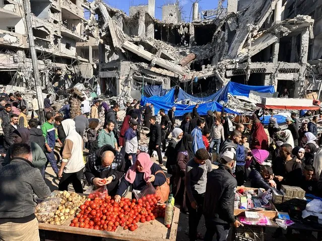 Palestinians, live in Nuseirat refugee camp, are seen shopping at a local bazaar during the humanitarian pause in Deir al-Balah, Gaza on November 30, 2023. Israel launched a massive military campaign in the Gaza Strip following a cross-border attack by Hamas on Oct. 7. (Photo by Ashraf Amra/Anadolu via Getty Images)