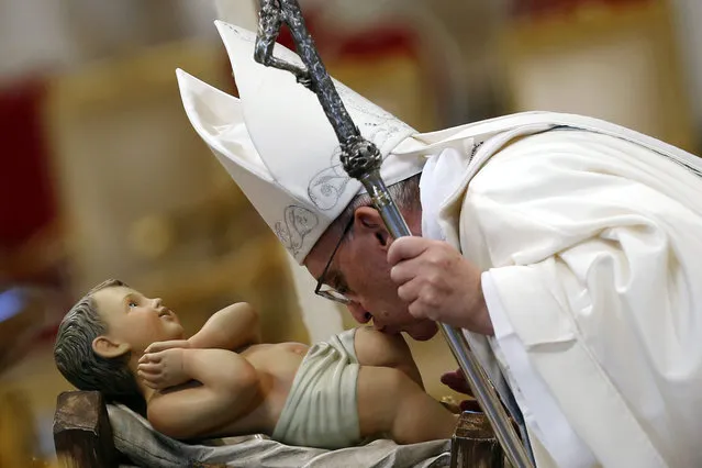 Pope Francis kisses a baby Jesus statue as he leads a mass at Saint Peter's Basilica at the Vatican January 1, 2014. (Photo by Giampiero Sposito/Reuters)
