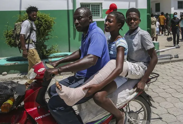 A child injured in the recent 7.2 magnitude earthquake leaves the Immaculee Conception hospital aboard a motorcycle, in Les Cayes, Haiti, Thursday, August 19, 2021. (Photo by Joseph Odelyn/AP Photo)