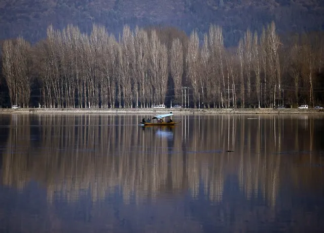 People row a boat in the waters of Dal Lake on a sunny winter day in Srinagar February 2, 2016. (Photo by Danish Ismail/Reuters)