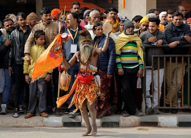 A Hindu holy man dances on a roadside as Hindi devotees stand on a road side during the inauguration of the Hindu Lord Ram temple in Ayodhya, India, on January 22, 2024. (Photo by Adnan Abidi/Reuters)