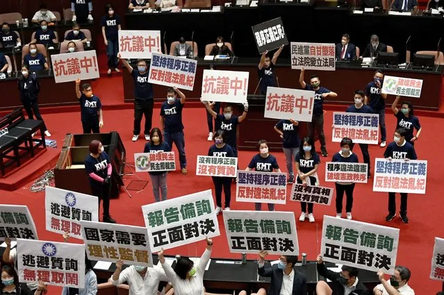 Taiwan's main opposition Kuomintang (KMT) legislators display placards that read “keep the Procedural Justice” as they protest calling for the government to apologise for coronavirus deaths, at the Parliament in Taipei on October 1, 2021. (Photo by Sam Yeh/AFP Photo)