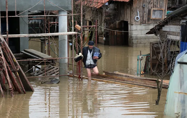 A man walks in front of a his flooded home in Pozega, some 150 kilometers south of Belgrade, Serbia, Monday, March 7, 2016. Rain-swollen rivers have flooded dozens of houses, farming land and roads in central Serbia, prompting authorities in several municipalities to declare emergency measures. (Photo by AP Photo)