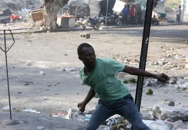 A protester throws a rock during clashes at a protest against the government in a street of Port-au-Prince, Haiti, February 9, 2019. (Photo by Jeanty Junior Augustin/Reuters)