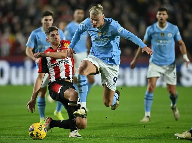 Manchester City's Norwegian striker #09 Erling Haaland jumps a challenge from Brentford's German midfielder #27 Vitaly Janelt during the English Premier League football match between Brentford and Manchester City at the Gtech Community Stadium in London on February 5, 2024. (Photo by Ben Stansall/AFP Photo)