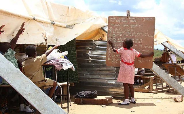 Primary students take lessons under a makeshift classroom because of lack of proper classrooms at the Eastview School in Caledonia, Harare, Zimbabwe, 14 March 2016. Students most of whom their parents are low income earners and informal traders, learn under very poor facilities. (Photo by Aaron Ufumeli/EPA)