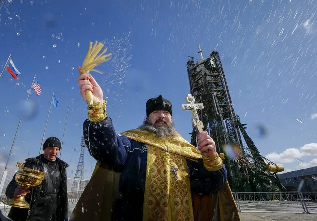 An Orthodox priest conducts a blessing in front of the Soyuz TMA-20M for the next International Space Station (ISS) crew, comprised of Jeff Williams of the U.S. and Oleg Skriprochka and Alexey Ovchinin of Russia, at the launchpad at the Baikonur cosmodrome, Kazakhstan, March 17, 2016, ahead of its launch scheduled on March 19. (Photo by Shamil Zhumatov/Reuters)