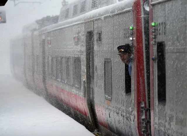 A train conductorlooks at the snow at the Metro North Greenwich train station on February 9, 2017 as  winter storms hit the area in Greenwich, Connecticut. (Photo by Timothy A. Clary/AFP Photo)