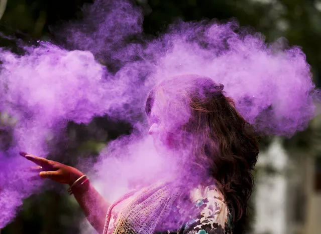 A Bangladeshi woman shuts her eyes as colored powder is smeared on her face during celebrations marking Holi, the Hindu festival of colors, in Dhaka, Bangladesh, Wednesday, March 23, 2016. The festival of colors, by painting each other in bright pigments, distributing sweets and squirting water at one another. The holiday celebrated mainly in India and Nepal marks the beginning of spring and the triumph of good over evil. (Photo by A.M. Ahad/AP Photo)