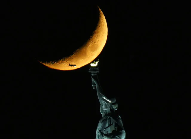 A Waxing Crescent Moon sets behind The Statue of Liberty on Monday, November 08, 2021 in New York City. (Photo by John Angelillo/UPI/Rex Features/Shutterstock)